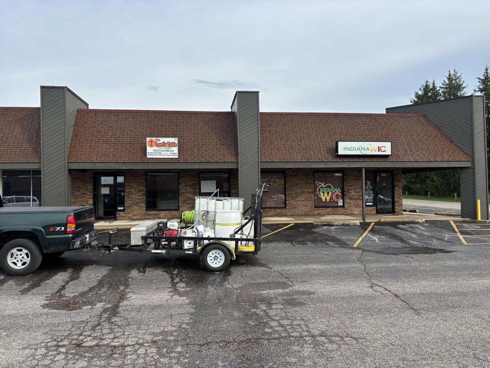 Strip center roof darkened by algae before cleaning