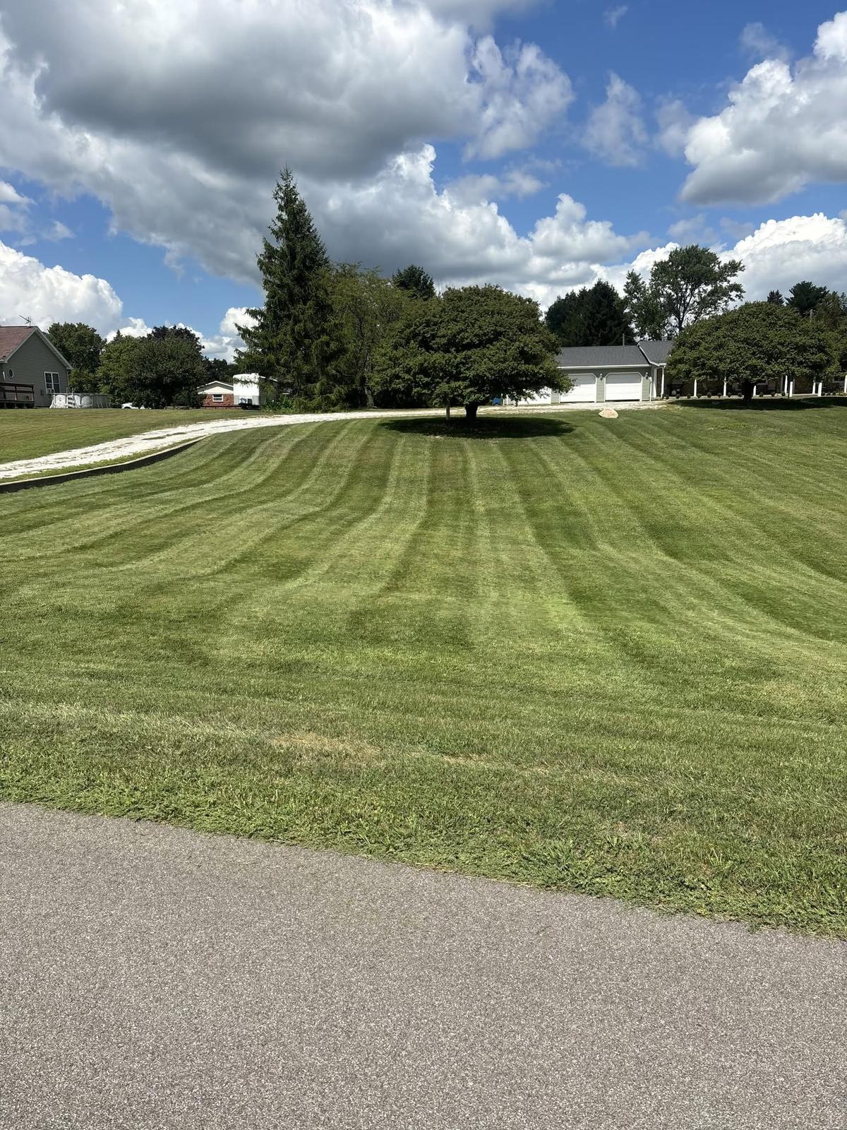 Large residential lawn mowed with clean alternating stripes